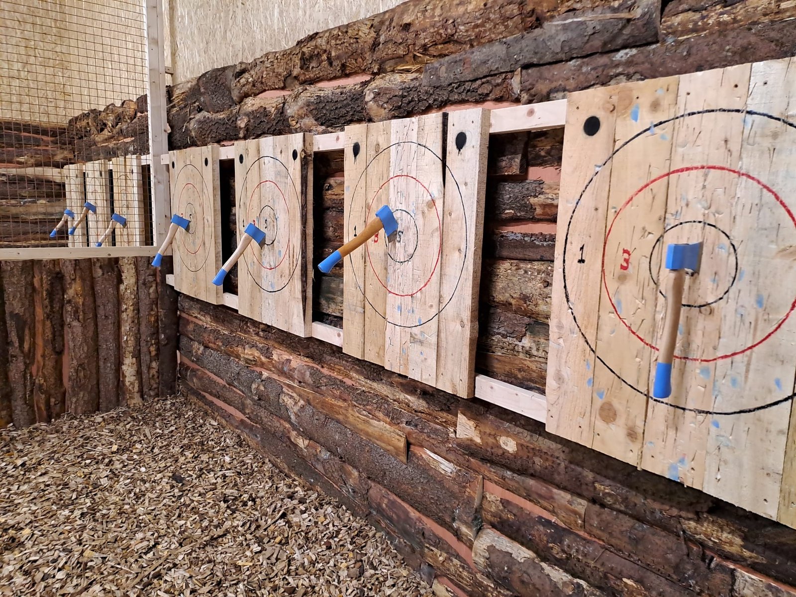 Five axes on five aiming boards on a wall